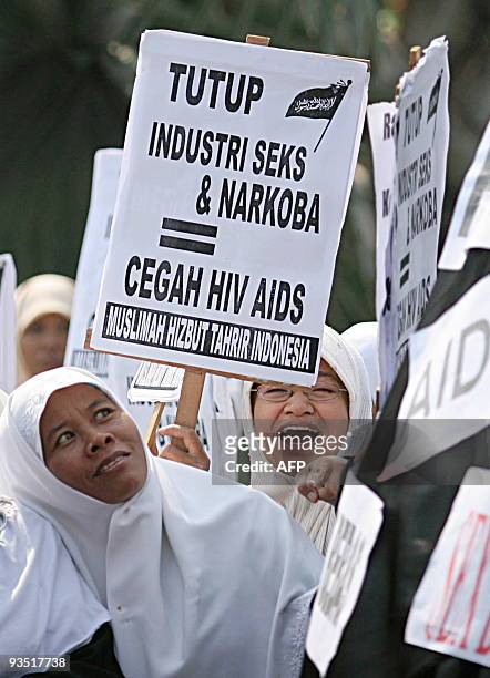 Indonesian Muslim women from Hizbut Tahrir hold a protest against the use of condoms as a solution to prevent HIV/AIDS in Surabaya on December 1,...