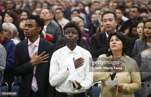 New U.S. Citizens James Maina from Kenya and Esther Ranfla from Mexico recite the pledge of allegiance along with other new citizens at a...