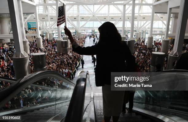 New U.S. Citizen waves an American flag while departing a naturalization ceremony on March 20, 2018 in Los Angeles, California. The naturalization...