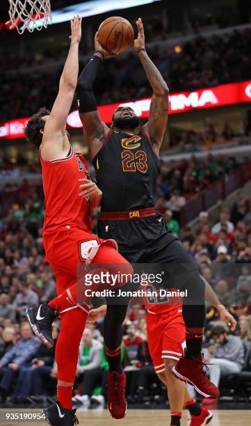 LeBron James of the Cleveland Cavaliers goes up for a shot against Paul Zipser of the Chicago Bulls at the United Center on March 17, 2018 in...