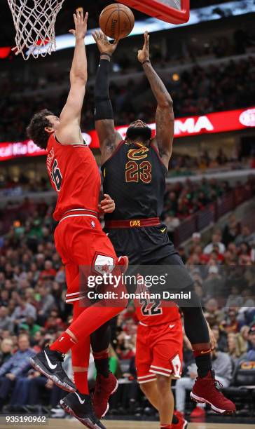 LeBron James of the Cleveland Cavaliers goes up for a shot against Paul Zipser of the Chicago Bulls at the United Center on March 17, 2018 in...