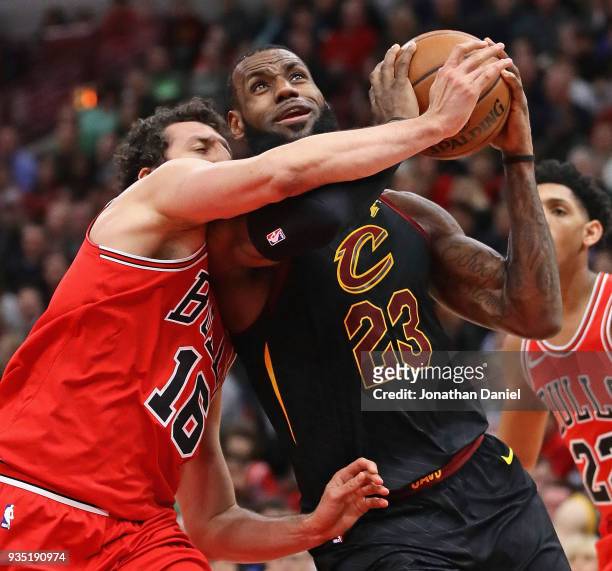 LeBron James of the Cleveland Cavaliers goes up for a shot against Paul Zipser of the Chicago Bulls at the United Center on March 17, 2018 in...