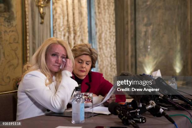 Rocxanne Deschamps wipes away tears as her attorney Gloria Allred looks on during a press conference at the Lotte New York Palace Hotel, March 20,...