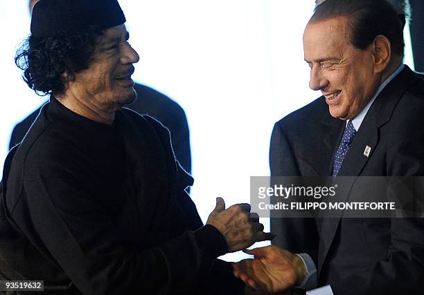 Libyan leader Moamer Kadhafi is greeted by Italian Prime Minister Silvio Berlusconi upon arrival at a World Summit on Food Security organized by the...