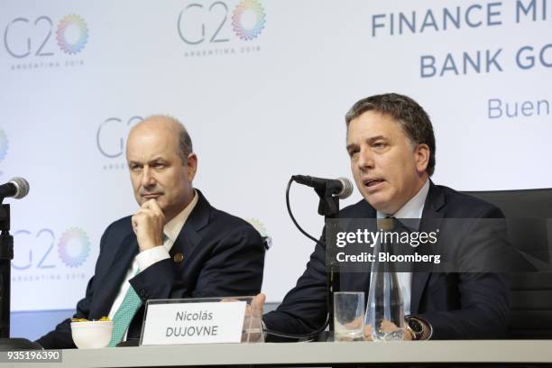 Nicolas Dujovne, Argentina's treasury minister, right, speaks while Federico Sturzenegger, president of the Central Bank of Argentina, listens during...