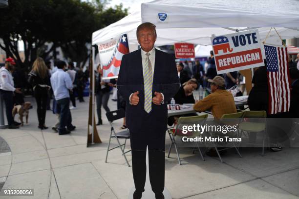 Cardboard cutout of U.S. President Donald Trump stands at a Republican voter registration tent following a naturalization ceremony on March 20, 2018...