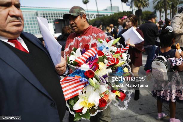 Vendor sells flowers with American flags following a naturalization ceremony on March 20, 2018 in Los Angeles, California. The naturalization...