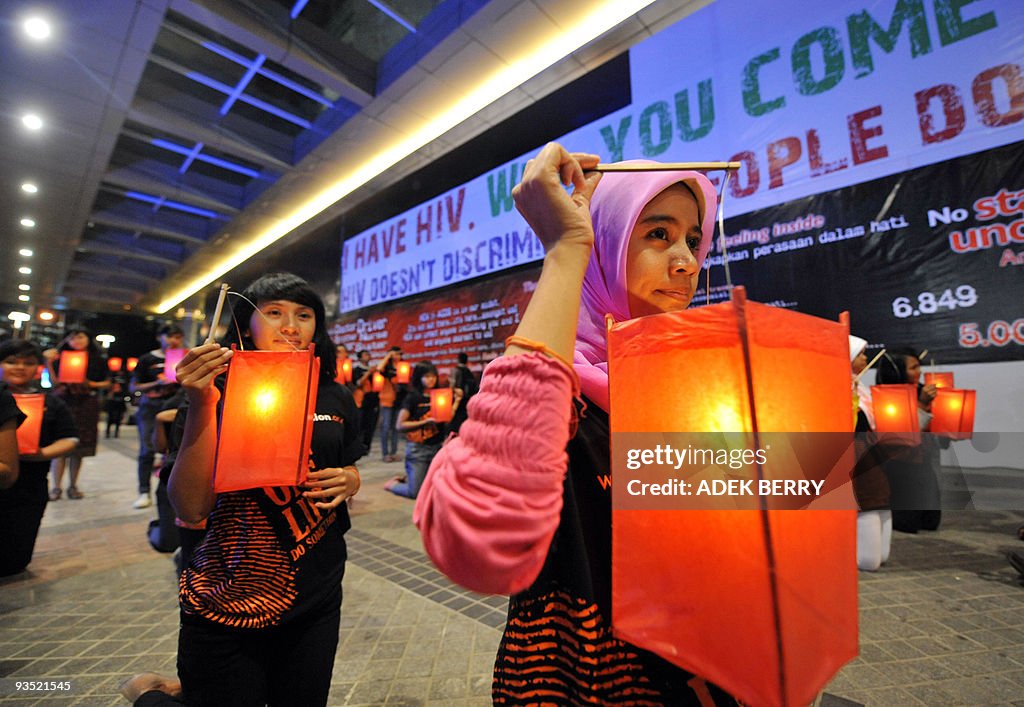 Indonesian volunteers hold lanterns duri