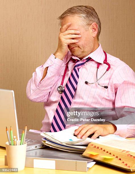 senoir gp doctor suffering from strain of work. - parsons green stock pictures, royalty-free photos & images