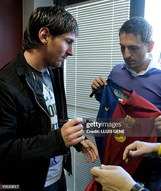 Barcelona's Argentinian forward Lionel Messi signs autographs after a press conference at the Ciutat esportiva Joan Gamper near Barcelona on December...