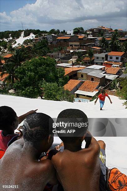 Children point to a slum in the Abaete lagoon in Salvador's metropolitan area, Bahia State, on November 30, 2009. The Abaete lagoon, a turistic site...