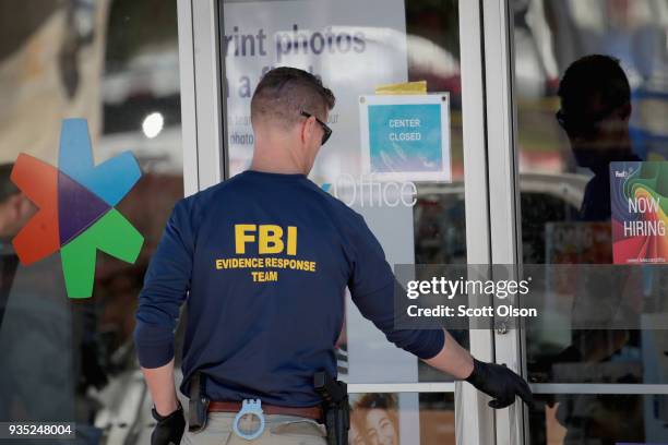 Agents collect evidence at a FedEx Office facility following an explosion at a nearby sorting center on March 20, 2018 in Sunset Valley, Texas. A...