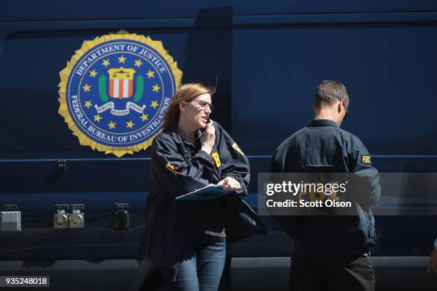 Agents collect evidence at a FedEx Office facility following an explosion at a nearby sorting center on March 20, 2018 in Sunset Valley, Texas. A...