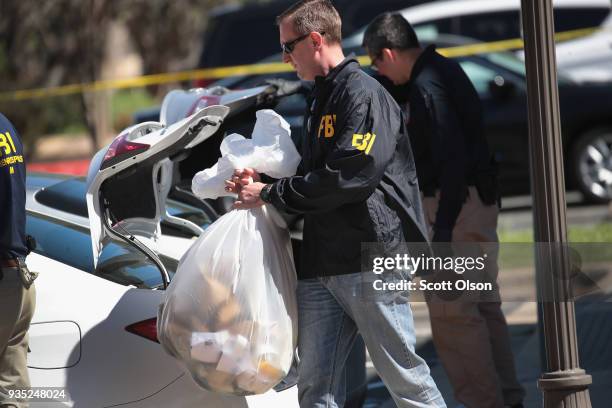 Agents collect evidence at a FedEx Office facility following an explosion at a nearby sorting center on March 20, 2018 in Sunset Valley, Texas. A...