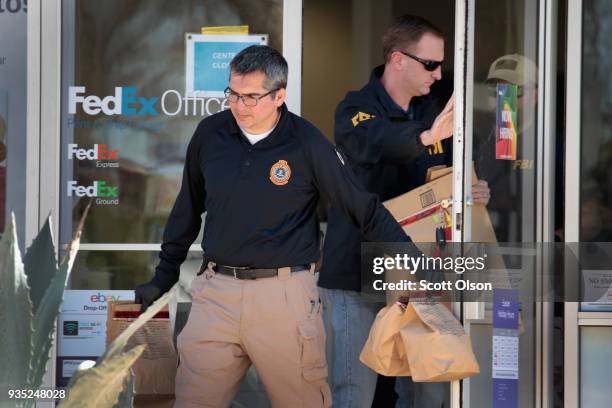 Agents collect evidence at a FedEx Office facility following an explosion at a nearby sorting center on March 20, 2018 in Sunset Valley, Texas. A...