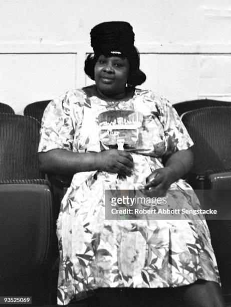 View of a woman fanning herself while attending a church service, possibly at the Christ Temple Apostolic Church, a storefront church in Chicago, IL,...