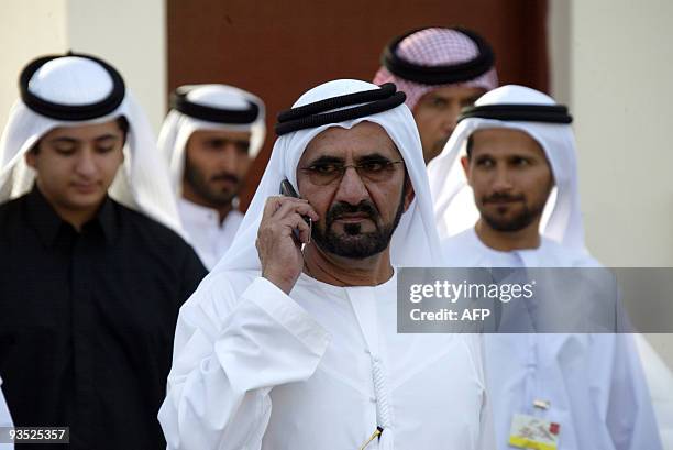 Prince of Dubai Sheikh Mohammed bin Rashed Al Maktoum speaks on his mobile as he visits the horses stable during the world's richest horse race, the...