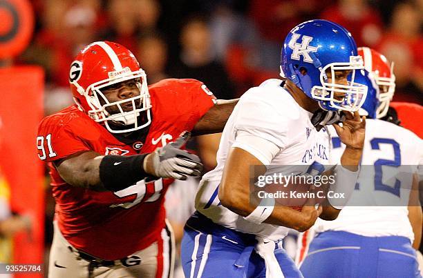 Quarterback Morgan Newton of the Kentucky Wildcats escapes a tackle by Kade Weston of the Georgia Bulldogs at Sanford Stadium on November 21, 2009 in...