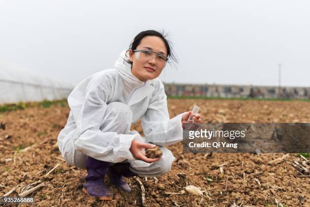 young female scientist holding test tube and soil - female likeness - fotografias e filmes do acervo