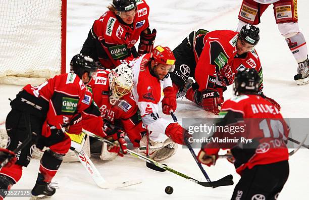 Goalkeeper Lars Weibel of Haie tries to save the puck against player of Scorpions during the Deutsche Eishockey Liga game between Koelner Haie and...