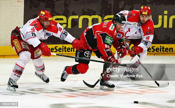 Kevin Hecquefeuille of Haie gets through Scorpions defence of Tore Vikingstad and Martin Hlinka during the Deutsche Eishockey Liga game between...