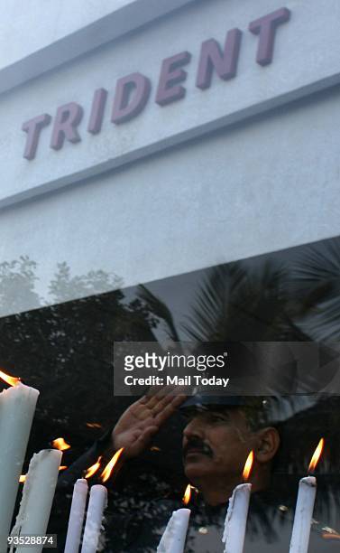 Employees of the Trident hotel, one of the sites of last year�s terror attacks light candles during a memorial service for victims on the first...
