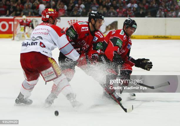 Ben Cottreau of Scorpions defends as Daniel Rudslaett and Moritz Mueller of Haie attack during the Deutsche Eishockey Liga game between Koelner Haie...