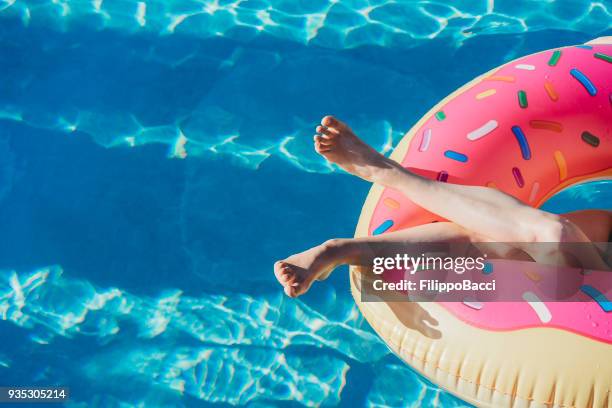 vrouw rustend op opblaasbare tijdens vakantie - inflate stockfoto's en -beelden