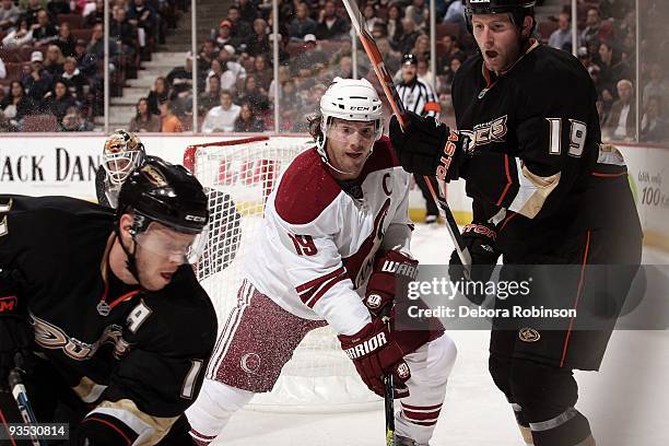 Shane Doan of the Phoenix Coyotes fights for the puck alongside the boards against Todd Marchant and Ryan Whitney of the Anaheim Ducks during the...