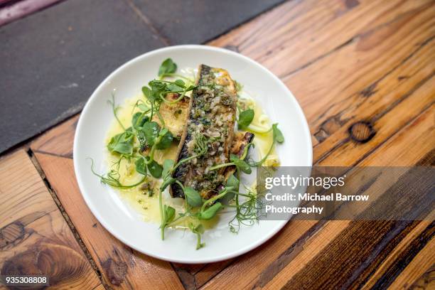 pan fried fish on rustic wooden background - makreel stock-fotos und bilder