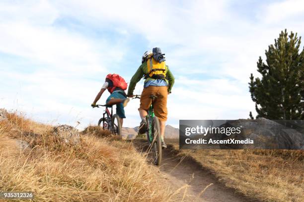 two men cycle along ridge on trail - colina acima imagens e fotografias de stock