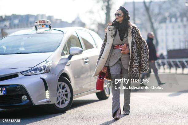 Guest wears sunglasses, a black cap, a grey geometrical patterned jacket, a white-lined red belt, a leopard-print coat, a red purse, a grey patterned...