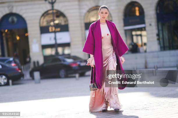 Landiana Cerciu wears a pale pink full-length, flounce-side dress, with flounce at the sleeves end, a fuchsia pagoda sleeves coat, a colorful...