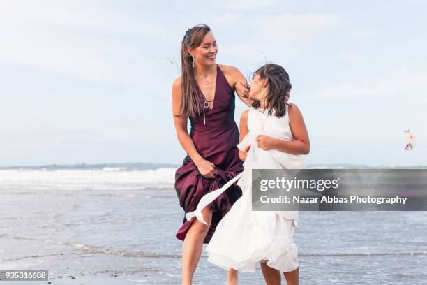 mother and daughter having fun during a walk at beach. - nazar abbas foto e immagini stock