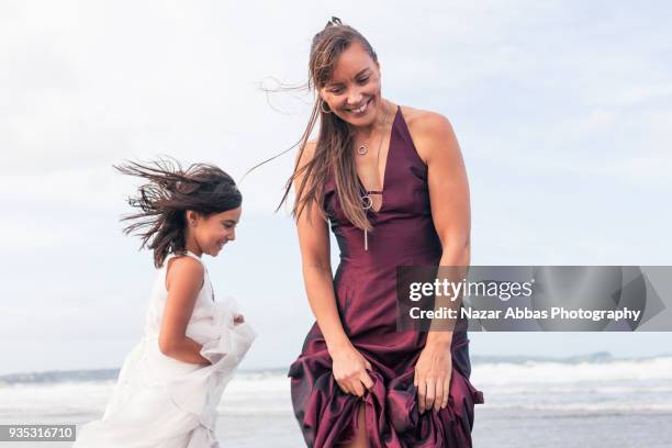 mother and daughter having fun during a walk at beach. - nazar abbas foto e immagini stock