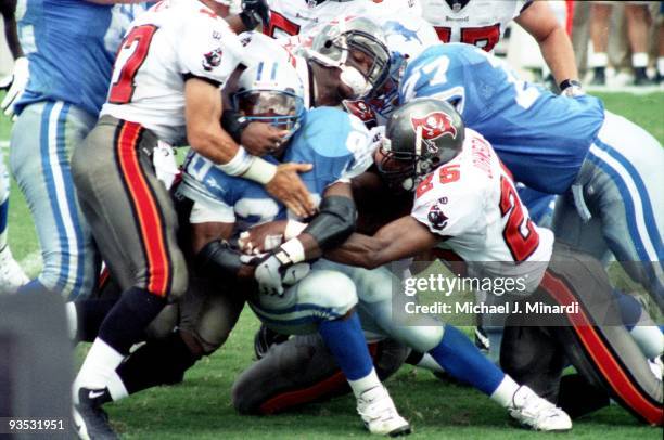 Running Back Barry Sanders of the Detroit Lions makes little yardage as he is tackled by Dirk Johnson of the Tampa Bay Buccaneers at Tampa Stadium on...