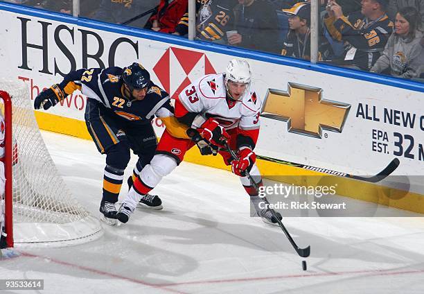 Tim Connolly of the Buffalo Sabres goes for the poke check as Bryan Rodney of the Carolina Hurricanes controls the puck during their NHL game on...