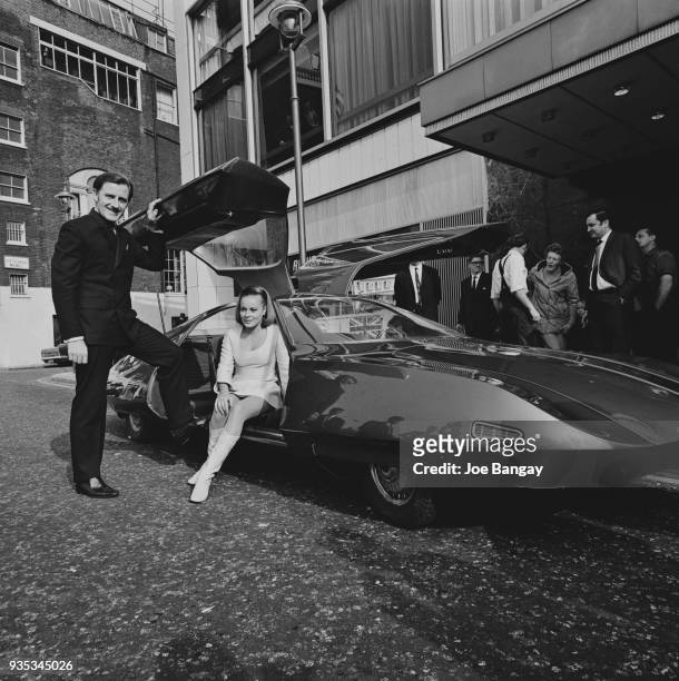 British racing driver Graham Hill and Austrian actress Loni Von Friedl with futuristic car 'Doppelganger' built by Alan Mann Racing, which was...