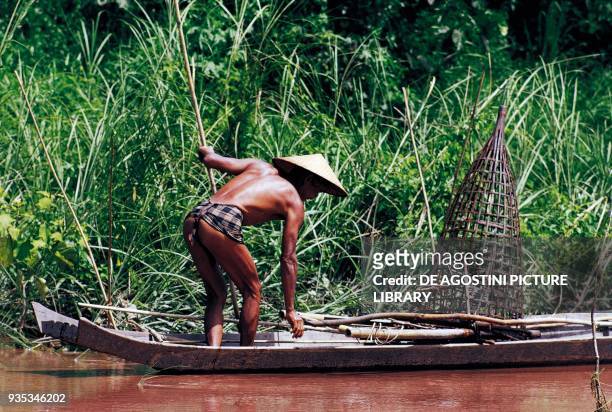 Fisherman in a canoe along the Mekong river, Laos.