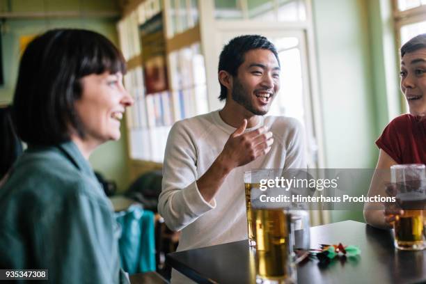 group of friends hanging out drinking together - beer on table stock pictures, royalty-free photos & images