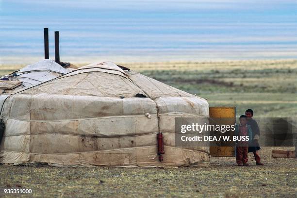 Children in front of a house, yurt, traditional nomadic dwelling, Gobi desert, Mongolia.