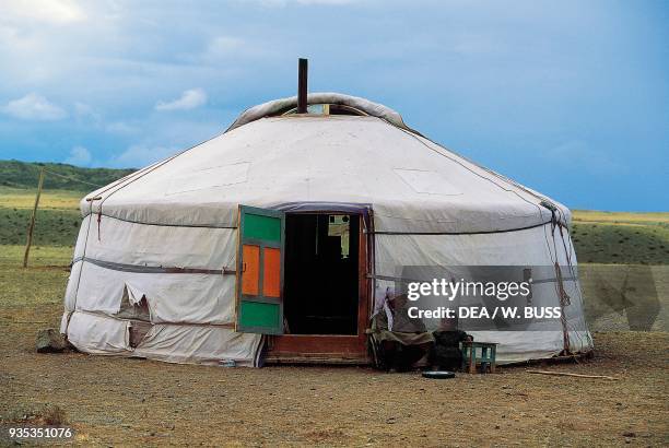 Woman with child in front of a house, yurt, traditional nomadic dwelling, Gobi desert, Mongolia.