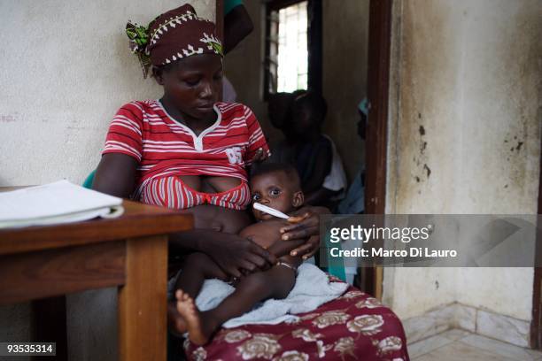 Woman and her children are seen waiting for HIV/AIDS volunteer testing and counseling during UNICEF Ambassador and Manchester United player Ryan...