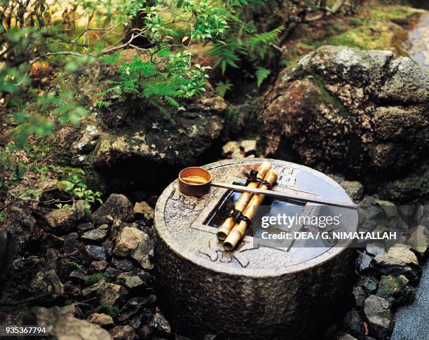 Decorated stone basin holding water for the purification of the hands and mouth, Ryoan-ji garden , Kyoto, Japan.