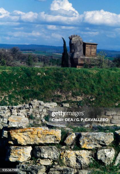 Ruins of Troy VI, wooden Trojan horse reconstruction in the background, archaeological site of ancient Troy , Hisarlik, Turkey.