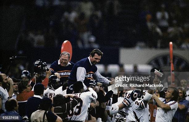 Super Bowl XX: Chicago Bears coach Mike Ditka and defensive coordinator Buddy Ryan victorious, getting carried off field by team after winning game...