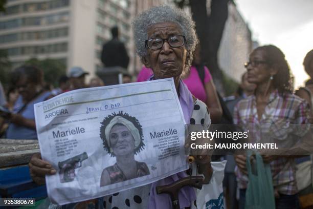 Protester shows a local newspaper during a demonstration against the murder of Brazilian councilwoman and activist Marielle Franco in front of Rio's...