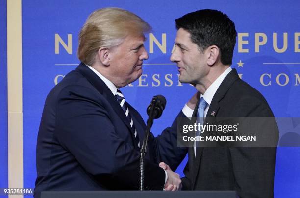 House Speaks Paul Ryan greets US President Donald Trump as he arrives on stage to speak at the National Republican Congressional Committee March...