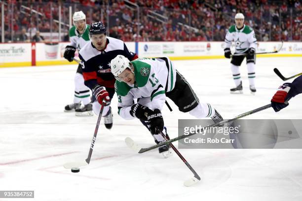 Mattias Janmark of the Dallas Stars and Dmitry Orlov of the Washington Capitals go after the puck in the first period at Capital One Arena on March...