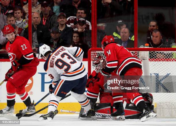 Scott Darling of the Carolina Hurricanes deflects the puck away on a shot on goal by Ryan Nugent-Hopkins of the Edmonton Oilers during an NHL game on...